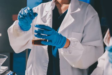 Bilimadamı laboratuarda tıbbi örnekleri mikro plakaya yerleştiriyor.