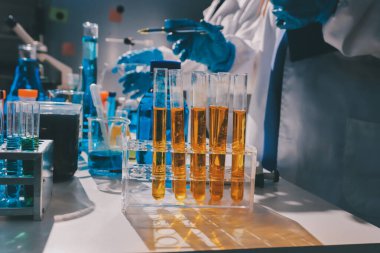 Bilimadamı laboratuarda tıbbi örnekleri mikro plakaya yerleştiriyor.