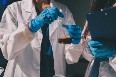 Bilimadamı laboratuarda tıbbi örnekleri mikro plakaya yerleştiriyor.