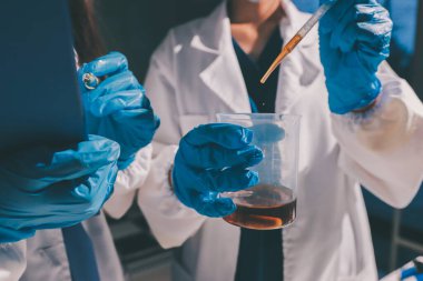 Bilimadamı laboratuarda tıbbi örnekleri mikro plakaya yerleştiriyor.