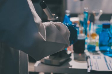 Bilimadamı laboratuarda tıbbi örnekleri mikro plakaya yerleştiriyor.