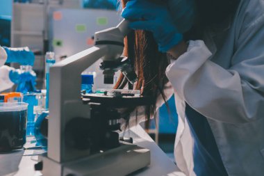 Bilimadamı laboratuarda tıbbi örnekleri mikro plakaya yerleştiriyor.