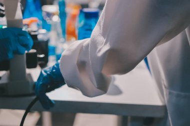 Bilimadamı laboratuarda tıbbi örnekleri mikro plakaya yerleştiriyor.
