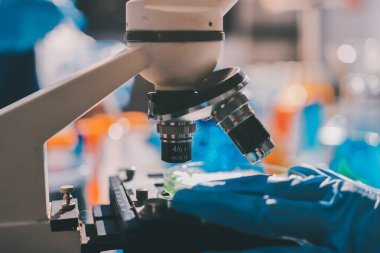 Bilimadamı laboratuarda tıbbi örnekleri mikro plakaya yerleştiriyor.