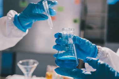 Bilimadamı laboratuarda tıbbi örnekleri mikro plakaya yerleştiriyor.