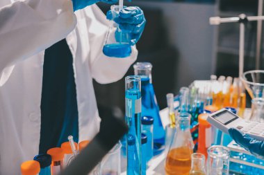 Bilimadamı laboratuarda tıbbi örnekleri mikro plakaya yerleştiriyor.