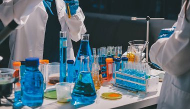 Bilimadamı laboratuarda tıbbi örnekleri mikro plakaya yerleştiriyor.