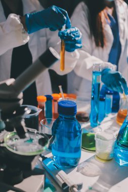 Bilimadamı laboratuarda tıbbi örnekleri mikro plakaya yerleştiriyor.