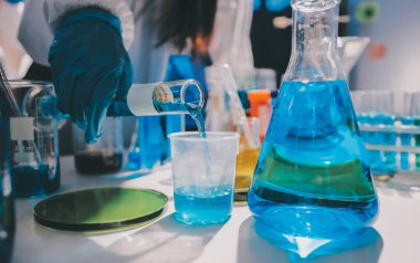 Bilimadamı laboratuarda tıbbi örnekleri mikro plakaya yerleştiriyor.