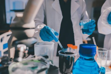 Bilimadamı laboratuarda tıbbi örnekleri mikro plakaya yerleştiriyor.