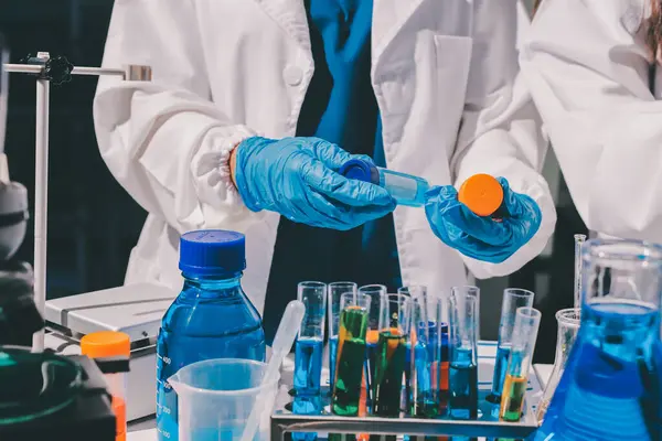 Bilimadamı laboratuarda tıbbi örnekleri mikro plakaya yerleştiriyor.