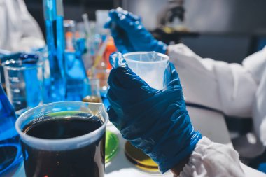 Bilimadamı laboratuarda tıbbi örnekleri mikro plakaya yerleştiriyor.