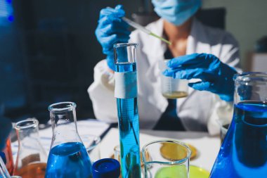 Bilimadamı laboratuarda tıbbi örnekleri mikro plakaya yerleştiriyor.