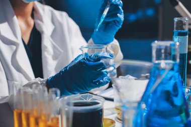 Bilimadamı laboratuarda tıbbi örnekleri mikro plakaya yerleştiriyor.