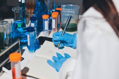 Bilimadamı laboratuarda tıbbi örnekleri mikro plakaya yerleştiriyor.