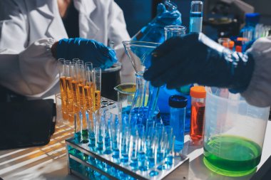 Bilimadamı laboratuarda tıbbi örnekleri mikro plakaya yerleştiriyor.