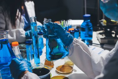 Bilimadamı laboratuarda tıbbi örnekleri mikro plakaya yerleştiriyor.