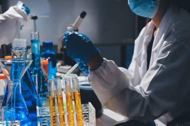 Bilimadamı laboratuarda tıbbi örnekleri mikro plakaya yerleştiriyor.