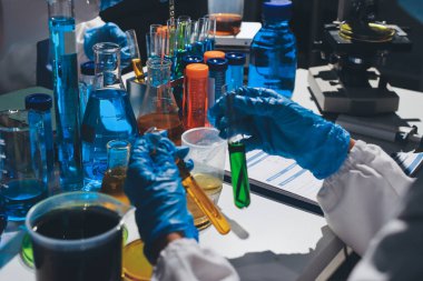 Bilimadamı laboratuarda tıbbi örnekleri mikro plakaya yerleştiriyor.