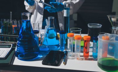 Bilimadamı laboratuarda tıbbi örnekleri mikro plakaya yerleştiriyor.