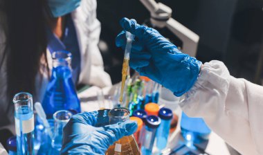 Bilimadamı laboratuarda tıbbi örnekleri mikro plakaya yerleştiriyor.