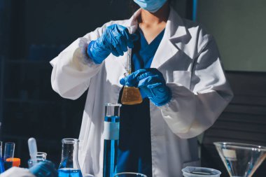 Bilimadamı laboratuarda tıbbi örnekleri mikro plakaya yerleştiriyor.