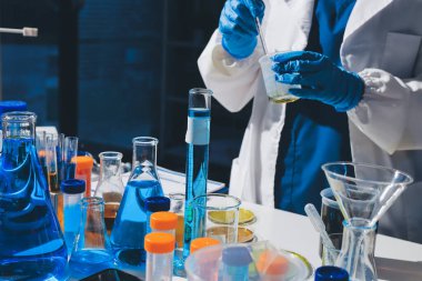 Bilimadamı laboratuarda tıbbi örnekleri mikro plakaya yerleştiriyor.