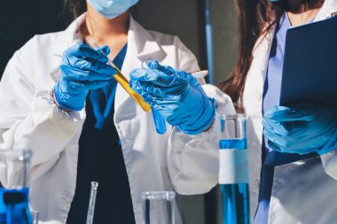 Bilimadamı laboratuarda tıbbi örnekleri mikro plakaya yerleştiriyor.