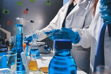 Bilimadamı laboratuarda tıbbi örnekleri mikro plakaya yerleştiriyor.