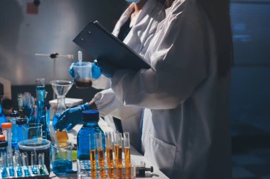 Bilimadamı laboratuarda tıbbi örnekleri mikro plakaya yerleştiriyor.