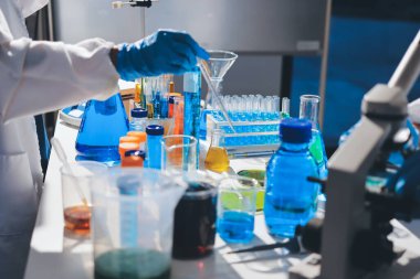 Bilimadamı laboratuarda tıbbi örnekleri mikro plakaya yerleştiriyor.