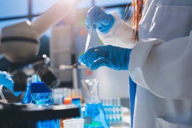 Bilimadamı laboratuarda tıbbi örnekleri mikro plakaya yerleştiriyor.