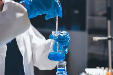 Bilimadamı laboratuarda tıbbi örnekleri mikro plakaya yerleştiriyor.