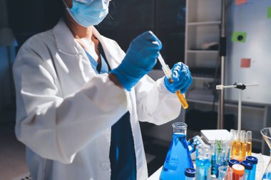 Bilimadamı laboratuarda tıbbi örnekleri mikro plakaya yerleştiriyor.