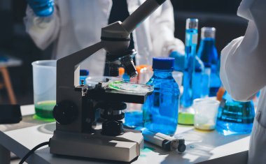 Bilimadamı laboratuarda tıbbi örnekleri mikro plakaya yerleştiriyor.