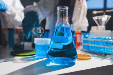 Bilimadamı laboratuarda tıbbi örnekleri mikro plakaya yerleştiriyor.