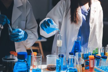 Bilimadamı laboratuarda tıbbi örnekleri mikro plakaya yerleştiriyor.