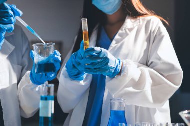 Bilimadamı laboratuarda tıbbi örnekleri mikro plakaya yerleştiriyor.