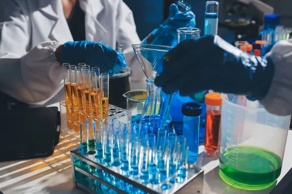 Bilimadamı laboratuarda tıbbi örnekleri mikro plakaya yerleştiriyor.