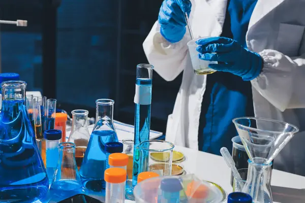 Bilimadamı laboratuarda tıbbi örnekleri mikro plakaya yerleştiriyor.