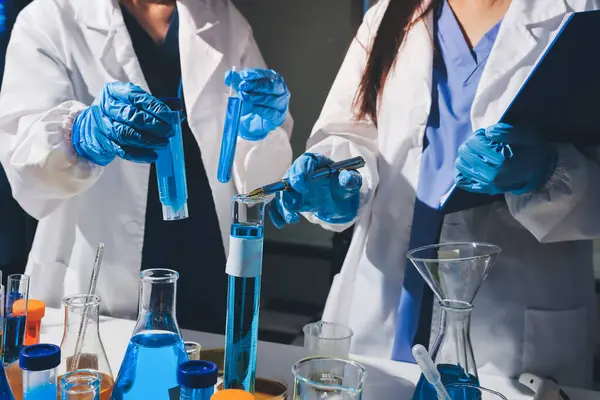 Bilimadamı laboratuarda tıbbi örnekleri mikro plakaya yerleştiriyor.