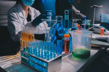 Bilimadamı laboratuarda tıbbi örnekleri mikro plakaya yerleştiriyor.