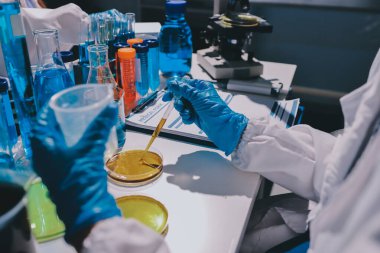 Bilimadamı laboratuarda tıbbi örnekleri mikro plakaya yerleştiriyor.