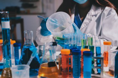 Bilimadamı laboratuarda tıbbi örnekleri mikro plakaya yerleştiriyor.