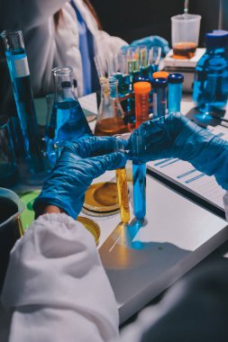 Bilimadamı laboratuarda tıbbi örnekleri mikro plakaya yerleştiriyor.