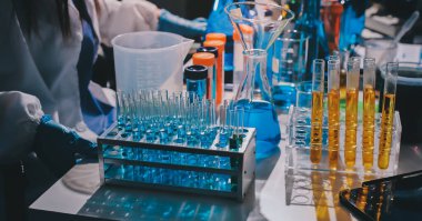 Bilimadamı laboratuarda tıbbi örnekleri mikro plakaya yerleştiriyor.