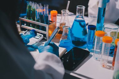 Bilimadamı laboratuarda tıbbi örnekleri mikro plakaya yerleştiriyor.