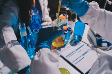 Bilimadamı laboratuarda tıbbi örnekleri mikro plakaya yerleştiriyor.