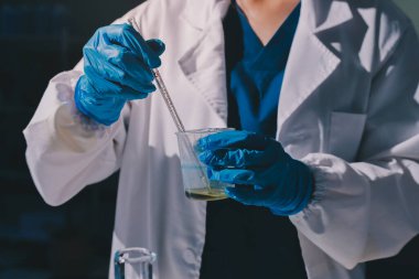 Bilimadamı laboratuarda tıbbi örnekleri mikro plakaya yerleştiriyor.