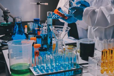 Bilimadamı laboratuarda tıbbi örnekleri mikro plakaya yerleştiriyor.